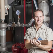 Technician inspecting heating system in boiler room