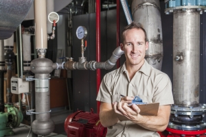 Technician inspecting heating system in boiler room