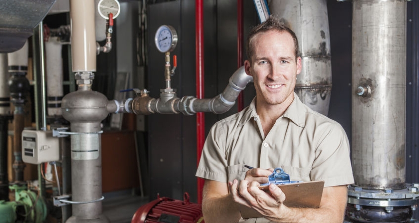 Technician inspecting heating system in boiler room